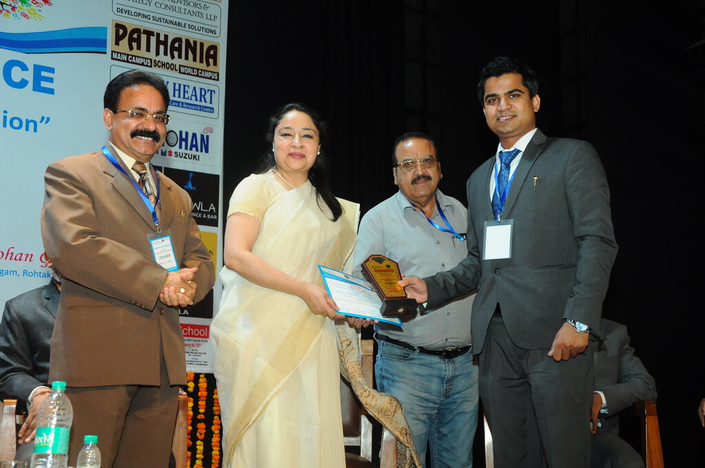 Advocate Naveen Arya presenting a memento to Ms. Ritu Y. K. Behl, District and Sessions Judge, on stage with co-organisers