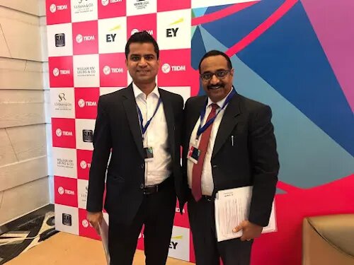 Advocate Naveen Arya at the TIDM corporate-advisory conference with a fellow tax and corporate practitioner